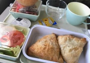 A vegan meal of samosas, salad and fruit served on a Vietnam Airlines flight