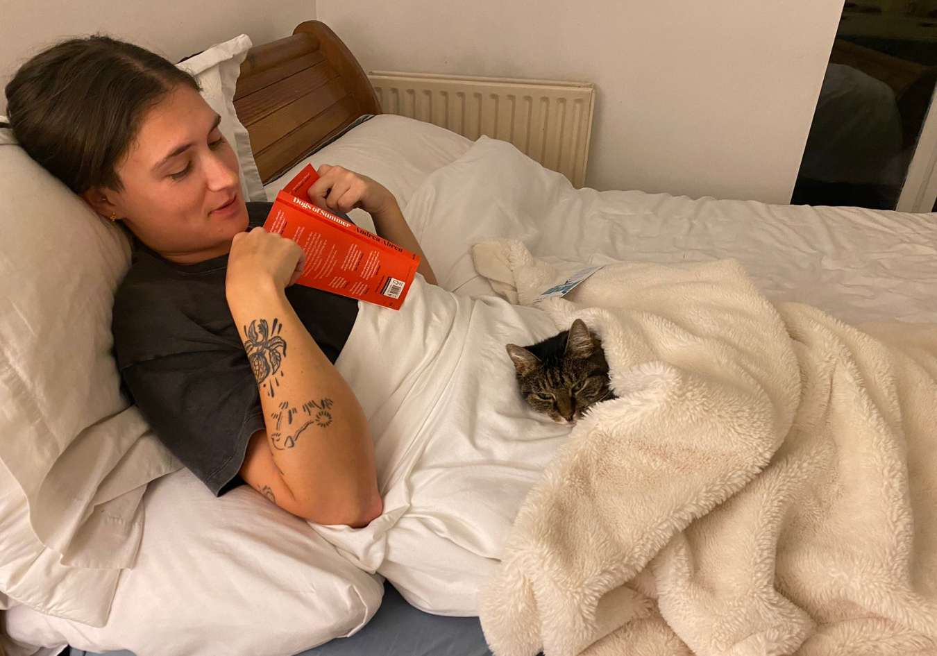 Lucy with Pumpkin on her lap whilst in bed on a sit through TrustedHousesitters - photo for this TrustedHousesitters review